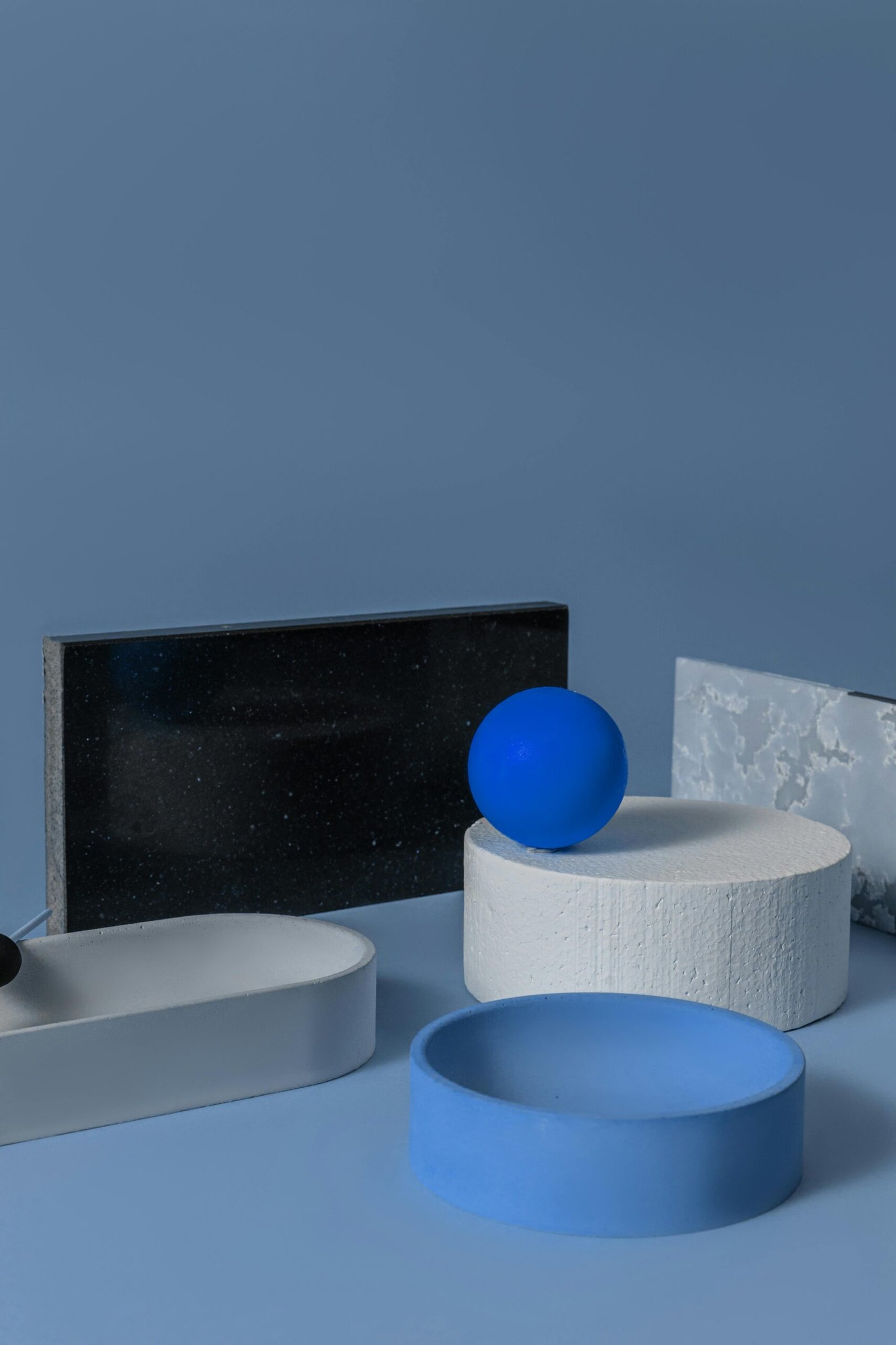 Abstract geometric shapes in minimalist style with blue hues on a studio setting.